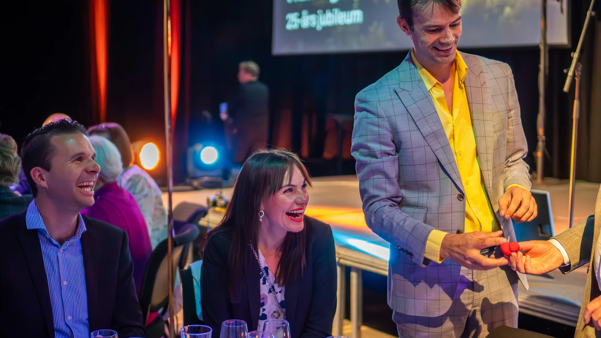 Gjester ler under trylling på firmaarrangement